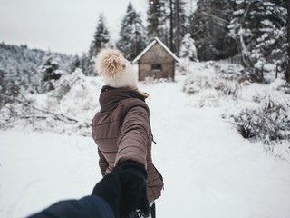 Fototapeta na wymiar Young couple winter adventures.winter ,Snow isolated.Hold each other hands,girl and her boyfriend walking in forest