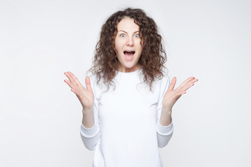 Overjoyed young pretty woman gestures actively being surprised to receive unexpected gift from...