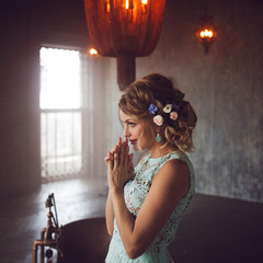 Young woman in lace dress and her hair decorated with flowers.