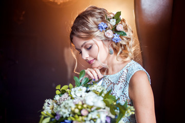 Naklejka premium Young beautiful woman in wedding dress with bouquet of flowers. Wedding hairstyle, flowers in hair.