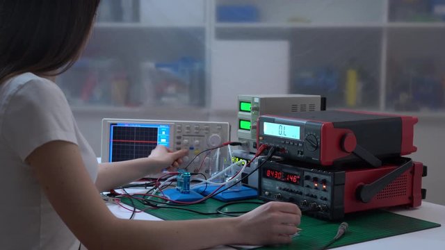 Young woman student in physics / electronics laboratory