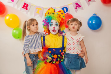 clown girl on the birthday of a child. Party for children. Clown with two little girls