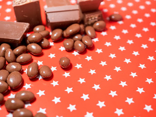 Pieces of chocolates on red background