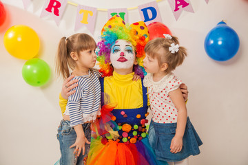 Fototapeta na wymiar clown girl on the birthday of a child. Party for children. Clown with two little girls