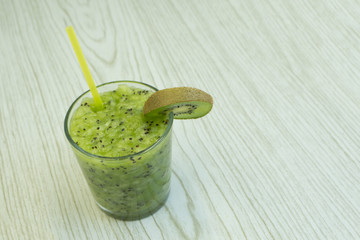A green smoothie on a tray with kiwi .