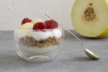 Homemade natural yogurt with melon and raspberry.