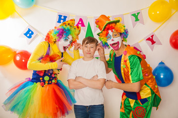 clown girl and clown boy at the birthday of a child. Party for children. Clowns try to cheer an adult boy