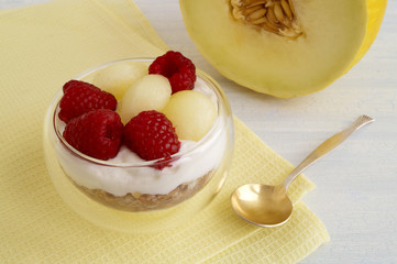 Homemade natural yogurt with melon and raspberry.