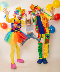 Obraz na płótnie Canvas clown girl and clown boy at the birthday of a child. Party for children. Clowns and little girl show different emotions