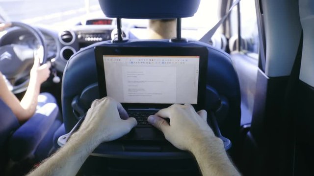 Typing on laptop while driving in car 4K