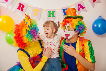 clown boy and clown girl on birthday girl. Party for children. Clowns amuse the child