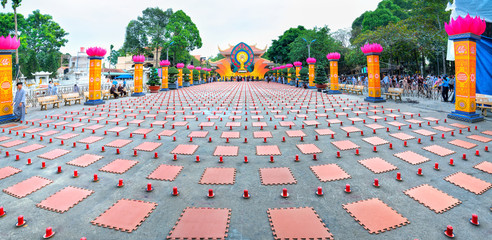Ho Chi Minh City, Vietnam - January 3, 2018: Buddhist party came prepared with hundreds candles lined Buddhists seat side prepare candles ceremonial Amitabha revered in Ho Chi Minh City, Vietnam