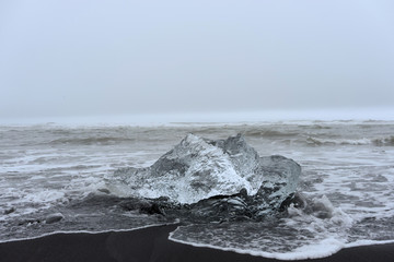 Ice in the sea with black sand
