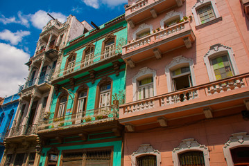 Traditional buildings in classic style with colorful facades on the background of blue sky with clouds. Havana. Cuba