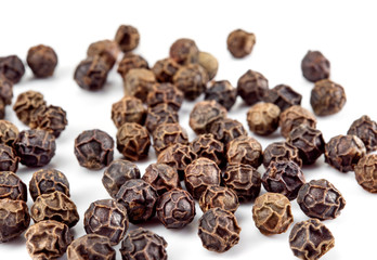Black pepper. Peppercorns isolated on white. Macro. Top view. Soft focus.