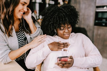 Freundinnen hören gemeinsam Musik