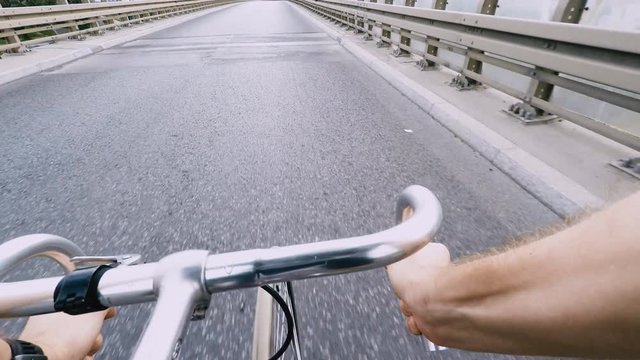 Speed riding a road bike on city street. Fixed gear classic road bicycle. View from first person perspective POV. Gimbal stabilized view, 4K video.