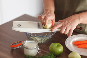 Woman slice kohlrabi in bowl