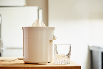Electric juicer and empty glass in a modern kitchen