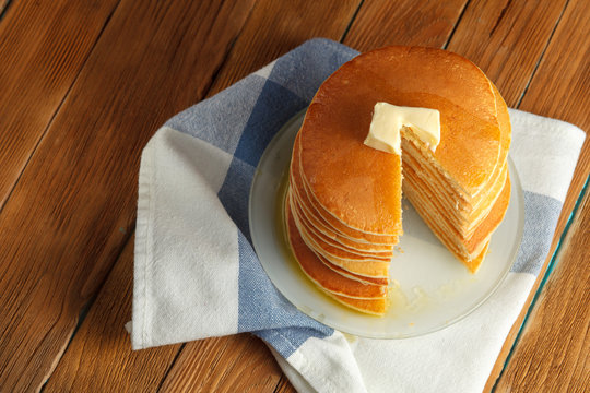 Top view of cut stack of pancake with honey and butter on top. Close up