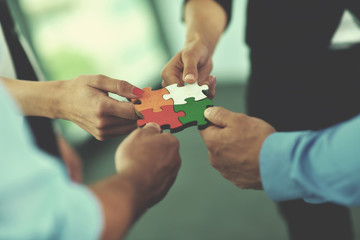 Group of business people assembling jigsaw puzzle