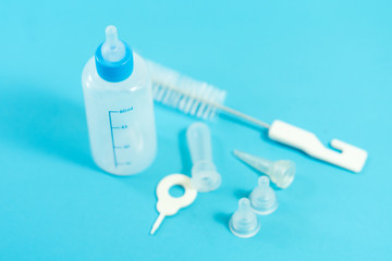 Pet accessories concept: Bottle feeding for pet and cleansing tools on blue background.
