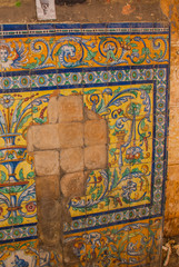 Fragment of ornament at the house close-up. Beautiful decor made of tiles. Flowers, vase and angels. Havana. Cuba