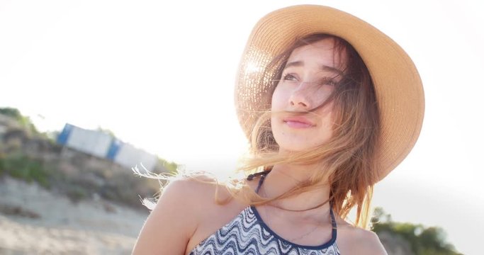 Beautiful young woman with summer hat at the beach