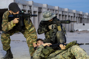 army soldier carries a wounded soldier evacuate at across the building