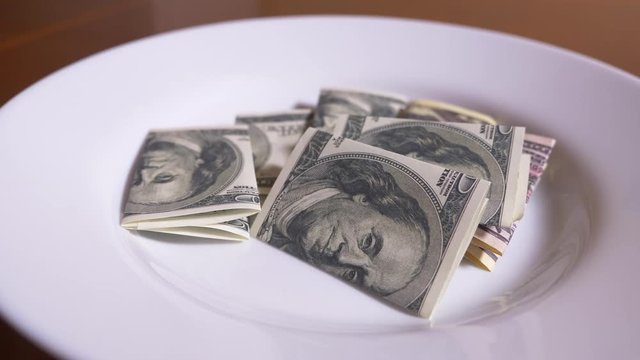 someone throws dollars into a plate. eat dollars. 4k.