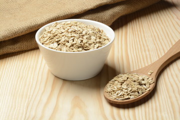 Avena cruda o copos sobre fondo de madera