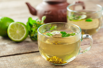 cup of black tea with mint leaves on a wooden table