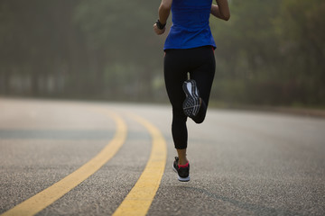 Fitness sportswoman running on sunrise trail