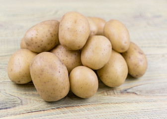 Potato tubers on a wooden background.