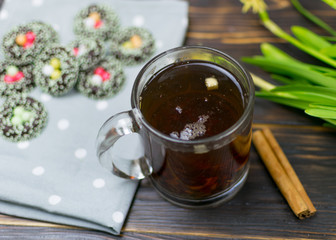 A cup with herbal tea and cookies on a dark background.