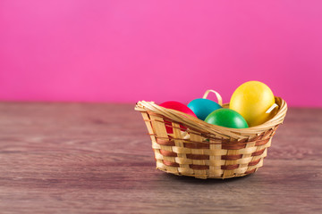 Easter basket filled with Easter Eggs over a colorful background