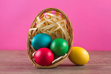 Easter basket filled with Easter Eggs over a colorful background