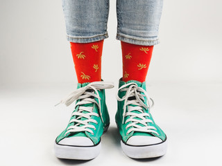 Stylish, bright, green sneakers and funny, happy socks on a white background. Sport, style, beauty, good mood