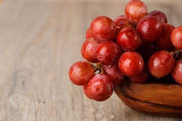bunch of red grapes in a wooden Cup