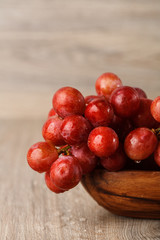 bunch of red grapes in a wooden Cup