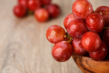 bunch of red grapes in a wooden Cup