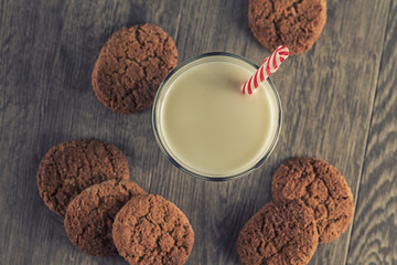 Cookies and a glass of milk on a wooden table. Vintage look.