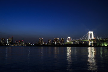 Fototapeta na wymiar Tokyo Bay with Rainbow Bridge in Background at Dusk