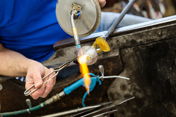 Artis heats glass made seagull statue using an acetylene gass torch