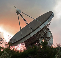 Radio telescope with rotary antenna at twilight sky background