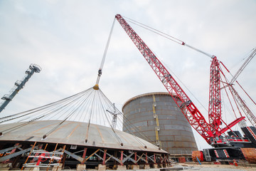 Construction of a production hall at a metallurgical plant factory with the help of a tower crane.