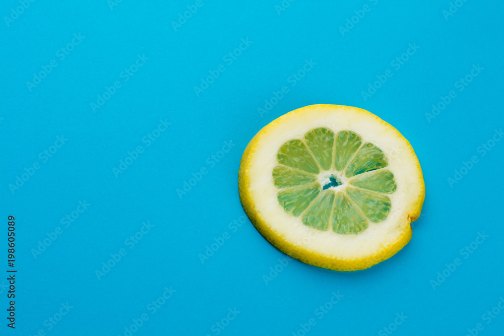 Wall mural yellow lemon slice against a blue background