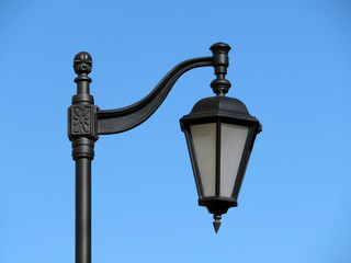 Fototapeta na wymiar Vintage iron street lamp isolated. City street lantern on the background of clear blue sky 