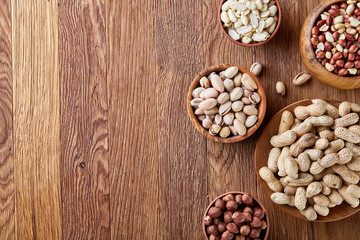 Fototapeta na wymiar A composition from different varieties of nuts in a wooden bowls on rustic background, close-up, shallow depth of field
