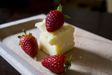composition of strawberries and parmesan cheese in a wooden dish